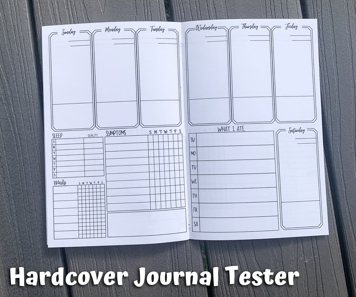 The hardcover tester is shown open. The top half and bottom right corner have a total of 7 tall boxes labeled each day of the week. There are 2 lines in the top right corner and one line near the bottom of each box. On the bottom left of the page is a sleep and med tracker. Next to these is a symptom box with a blank rectangular box below for notes. A What I Ate section is on the right page to the left of the saturday box.