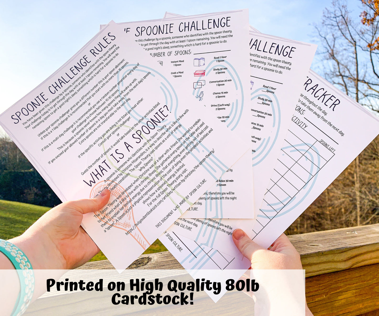 Each page of the Spoonie Challenge set is shown being held up. They are unlaminated. A note says Printed on High Quality 80 pound cardstock. The pages in the set are the spoonie challenge rules and spoonie definition, 2 value pages with preset or blank values, and a spoon use tracker.