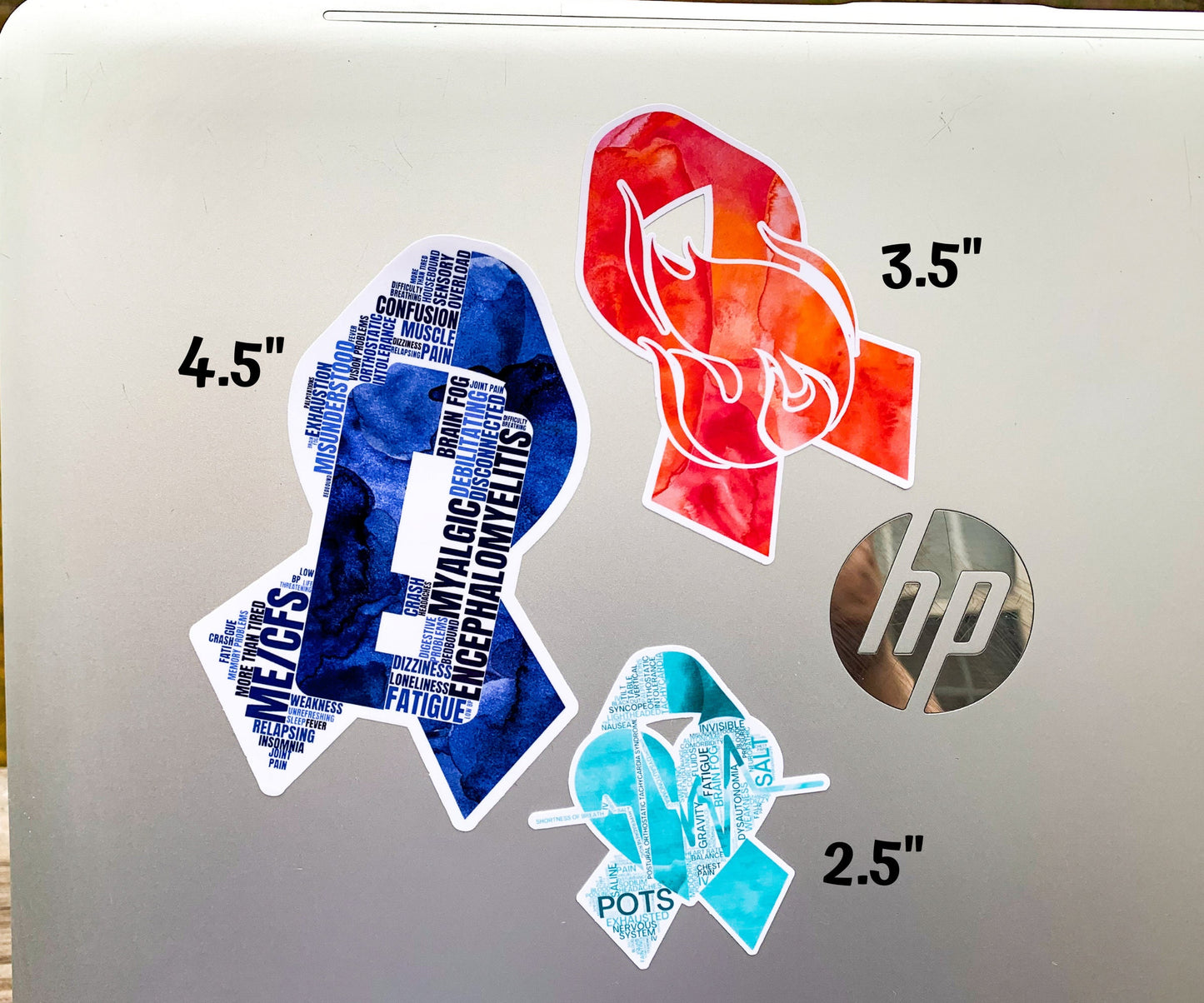 3 Stickers are shown on a silver laptop.