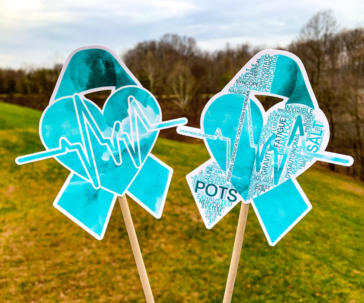 The word cloud and watercolor designs are shown on 2 sticks. Both ribbons feature a turquoise awareness ribbon with a heart and heart beat line in the center. The word cloud design on the right is split in half with a word cloud on the left half of the ribbon and heart beat and right half of the heart.