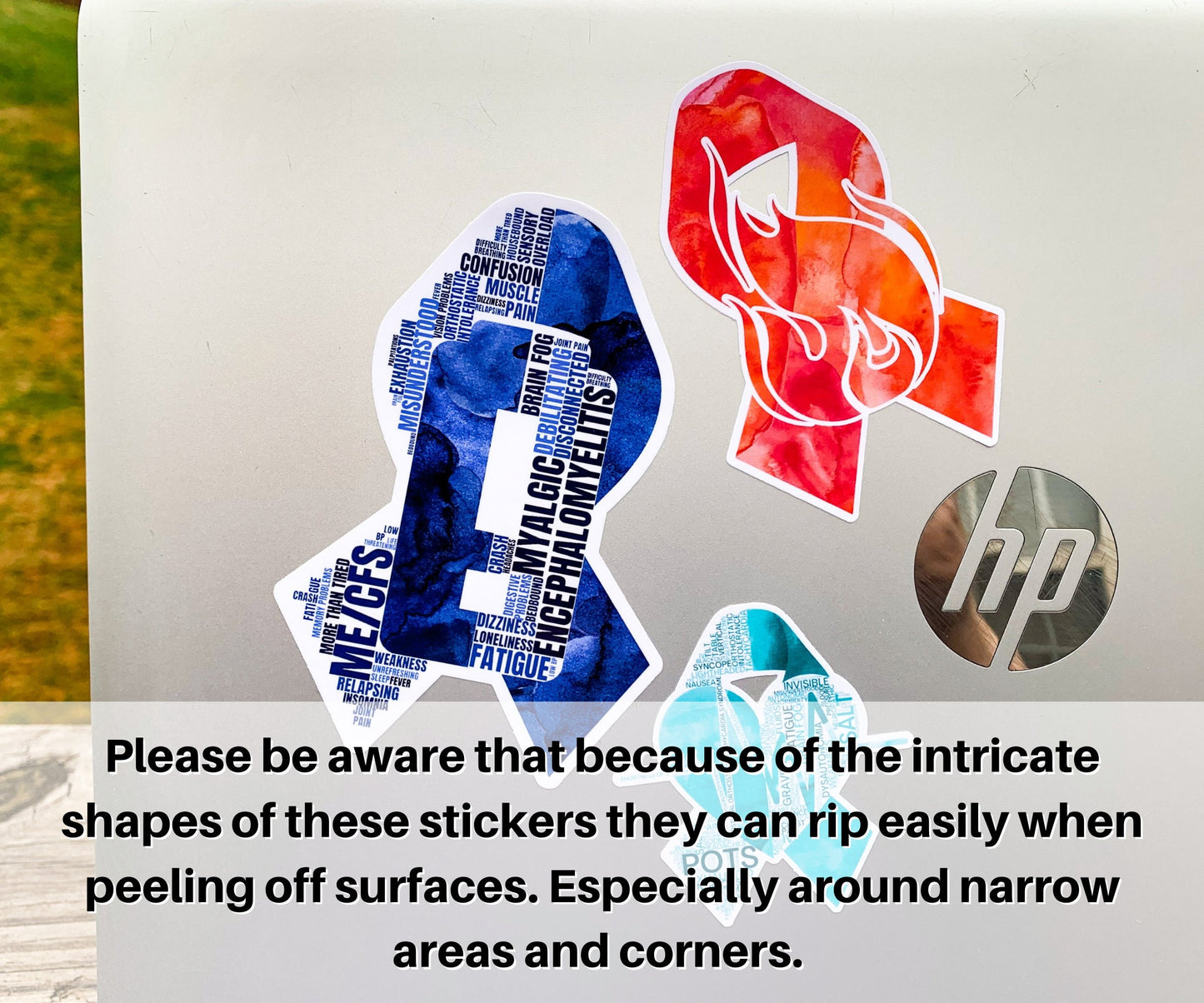 3 Stickers are shown on a silver laptop. A note says please be aware that because of the intricate shapes of these stickers they can rip easily when peeling off surfaces. Especially around narrow areas and corners.