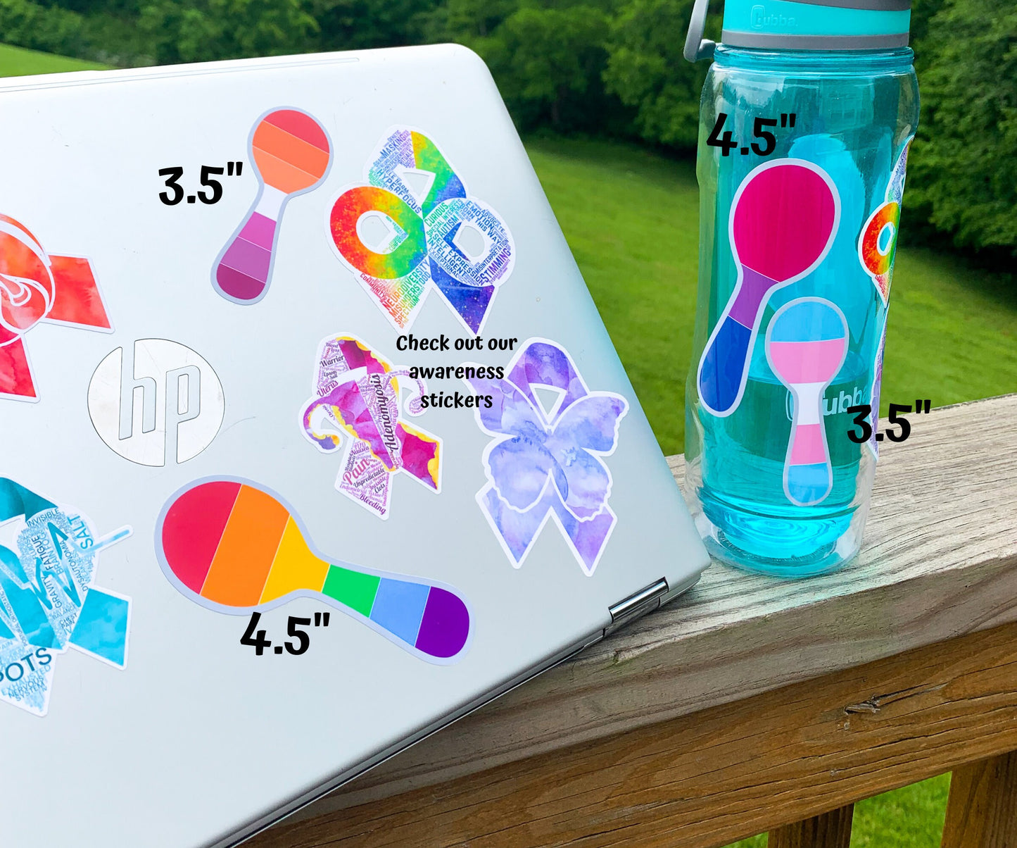 The teal waterbottle is shown next to a silver laptop with several stickers on it. The stickers have sizes labeled next to them. A 4 1/2 inch rainbow spoon and 3 1/2 inch lesbian spoon sticker are shown on the laptop and the 4 1/2 inch bisexual and 3 1/2 trans pride spoon stickers are shown on the waterbottle. The autism, adenomyosis, CRPS, POTS, and Fibromyalgia stickers can be seen on the laptop with a note that says check out our awareness stickers.