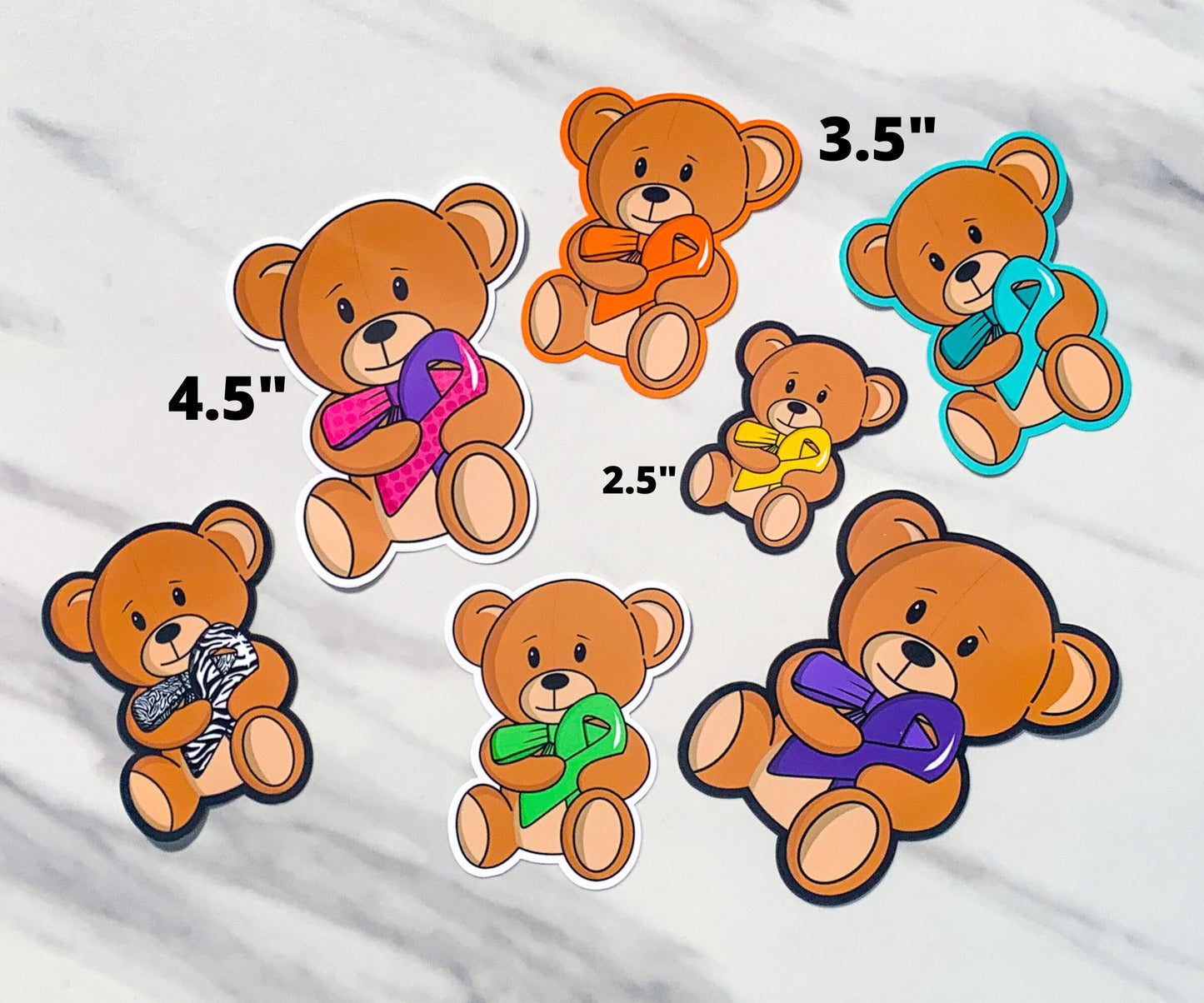 Several bears are shown with sizes. A tiny bear with a yellow ribbon is shown as 2.5 inches. 2 bears with turquoise and orange ribbons (matching outlines) are shown as 3.5 inches. The purple pink polka dot ribbon bear shown before is marked as 4.5 inches. Purple, green, and zebra ribbon bears are also shown. The zebra bear has a tighter zebra design on the bow tie versus the ribbon.