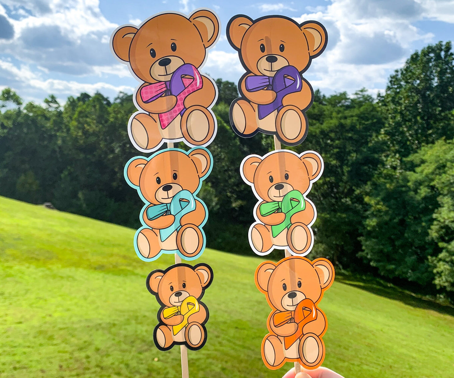 The same bears shown before are shown again on sticks. The purple and yellow bears have black outline, the turquoise and orange bears have matching outlines, and the purple pink dot and green bears have white outlines.