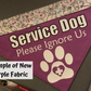 A purple bandana is shown on a grey square. The bandana has the new fabric contrast pocket at the top and has the Ignore Us Paw design. The paw and plus are all white on a purple bandana. A box says Example of New Purple Fabric, purple is not shown in other photos because it is a new addition.