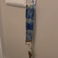  A video showing a starry night colored wristlet with keys attached is shown being taken off a hook on the wall and slipped on handed onto a wrist