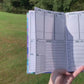 A video shows move left to right showing the main page of the symptom journal. The book is then opening laying down and is flicked to different pages to show what is in the book. The pages shown in order are the month page, main tracking page,then in the back medication and test history, doctor information, and lined pages