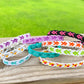 Several bracelets are shown stacked on each other displaying the different colors and combos they come in. 