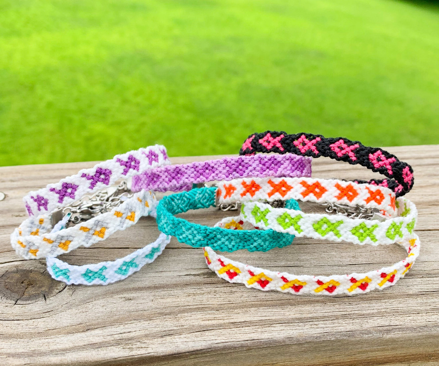 Several bracelets are shown stacked on each other displaying the different colors and combos they come in. 
