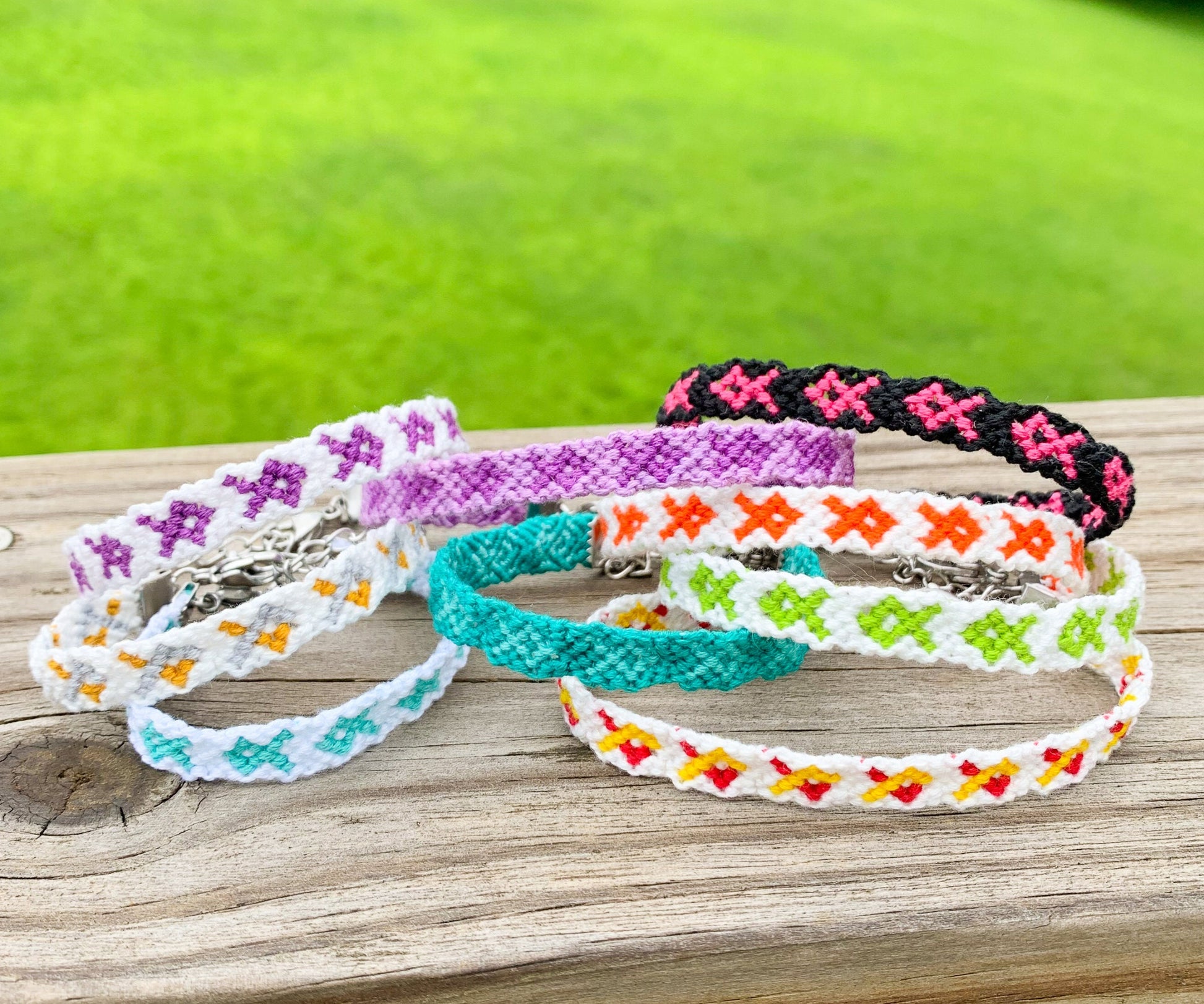 Several bracelets are shown stacked on each other displaying the different colors and combos they come in. 