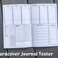 The hardcover tester is shown open. The top half and bottom right corner have a total of 7 tall boxes labeled each day of the week. There are 2 lines in the top right corner and one line near the bottom of each box. On the bottom left of the page is a sleep and med tracker. Next to these is a symptom box with a blank rectangular box below for notes. A What I Ate section is on the right page to the left of the saturday box. 