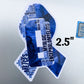 The 2.5 inch word cloud ribbon is shown on a silver laptop, some of the smallest words are harder to see but many of the words are visible. Words like Myalgic Encephalomyelitis, Brain Fog, Disconnected, Crash, Misunderstood, Confusion, Sensory Overload, Loneliness, Low BP, and more.