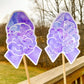 The word cloud and watercolor designs are shown on 2 sticks. Both ribbons feature a purple color awareness ribbon with a brain in the center. The word cloud design on the left is split in half with a word cloud on the left half of the ribbon and right half of the brain.