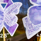 A close up of the 2.5 and 4.5 in word cloud ribbons are shown. You can see the words clearly in matching shades of purple. The words are things like Nerve, Widespread, Memory, Fatigue, Chronic, Fibromyalgia, Tissue, Spoonie, Pressure, Gaslighting, Illness, Flare, Misunderstood, Disease, and more. 
