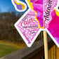 A close up is shown of the word cloud ribbon. You can see the words clearly in matching magenta and pink colors. The words are things like Pain, Cramps, Uterine Wall, IUD, Bleeding, Endometrial Tissue, Clots, Pressure, Unpredictable, and more.
