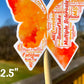 A close up of the 2.5 in word cloud ribbon is shown. You can see the words matching shades of orange, some of the smaller words are hard to see however this may be photo quality. The words are things like Snowflake, Multiple Sclerosis, Balance, Invisible, Spinal Cord, Lesions, Vision, Remors, Fatigue, Weakness, Spasms, and more.