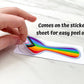 A hand is shown peeling off the progressive pride sticker from the sticker paper. A note says comes on the sticker sheet for easy peel off.