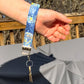 The starry night wristlet is shown hanging on a wrist. 2 Keys are attached the key loop. 